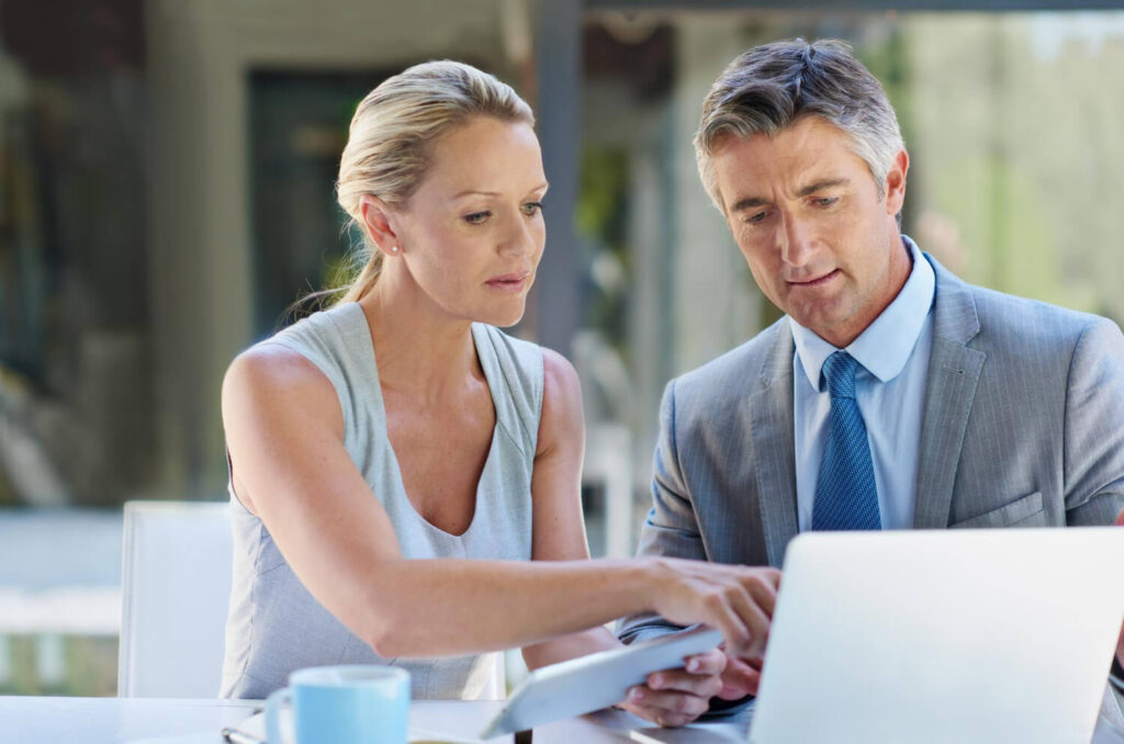 Couple face à un notaire avec des documents de vente immobilière non signés