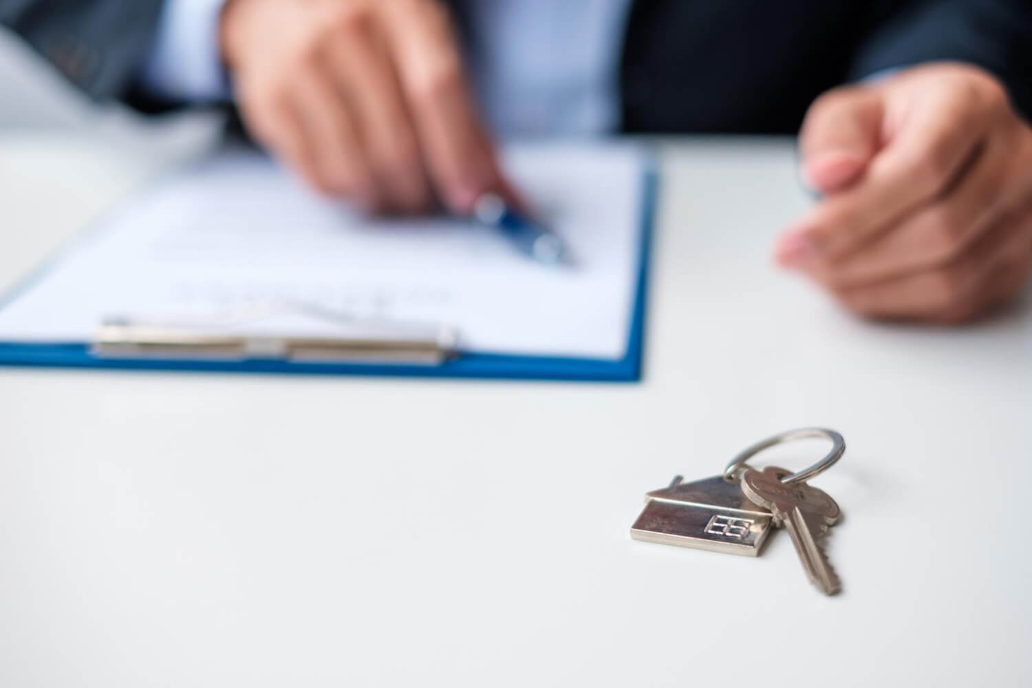 Clé de maison sur un compromis de vente, illustrant le problème d'un vendeur qui fait traîner la vente.