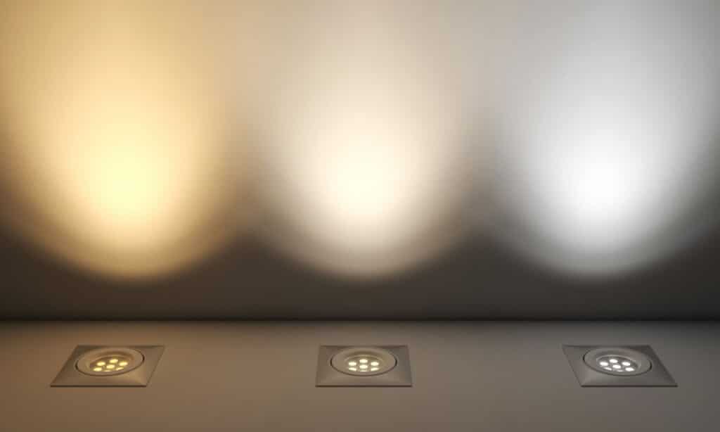 Comparaison de trois ampoules LED identiques éclairant un mur, montrant un blanc chaud, un blanc neutre et un blanc froid.