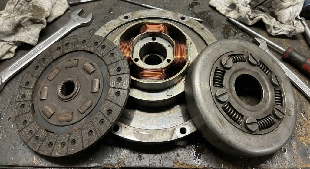 Vue détaillée d'un embrayage de lames électromagnétique démonté montrant le disque, la bobine et les fentes de réglage.