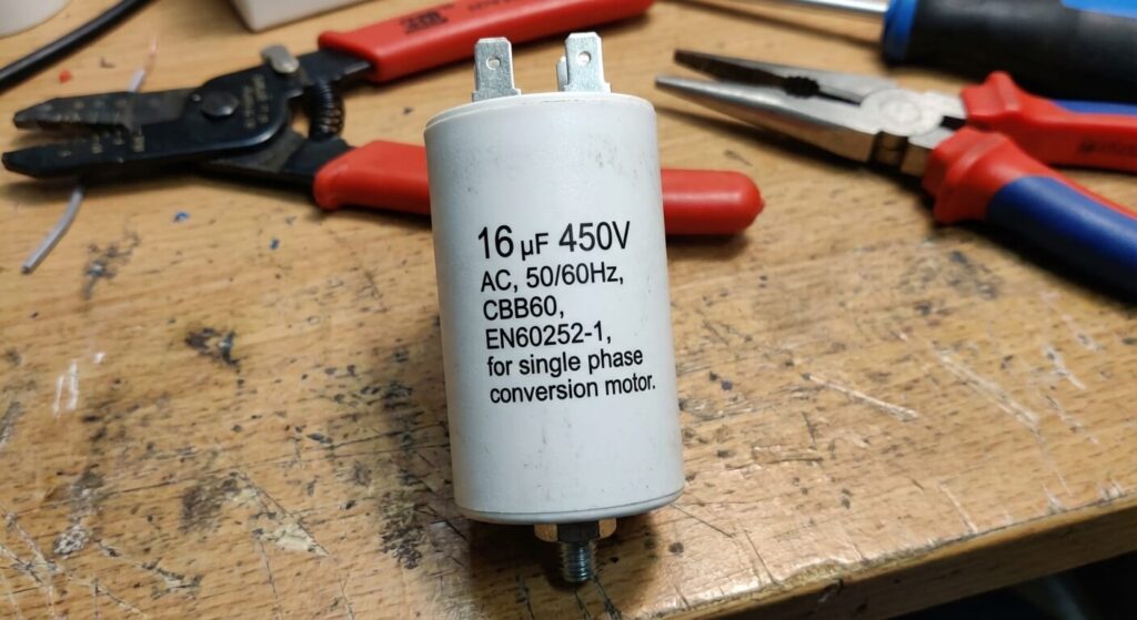 Condensateur blanc en polypropylène affichant sa capacité en microfarads pour la conversion monophasée