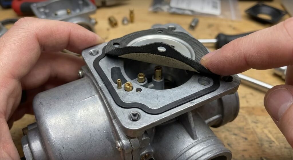 Gros plan sur la superposition correcte du joint et de la membrane sur le corps du carburateur