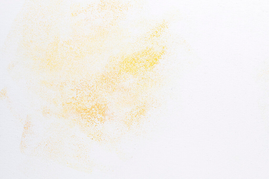 Une tache jaune d'humidité ou de nicotine sur la surface d'un mur en plâtre intérieur avant rénovation.