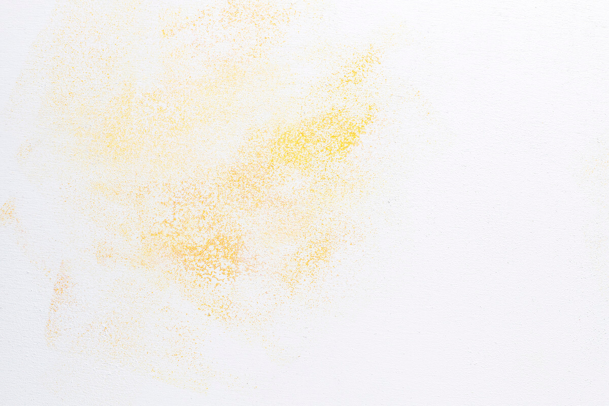 Une tache jaune d'humidité ou de nicotine sur la surface d'un mur en plâtre intérieur avant rénovation.