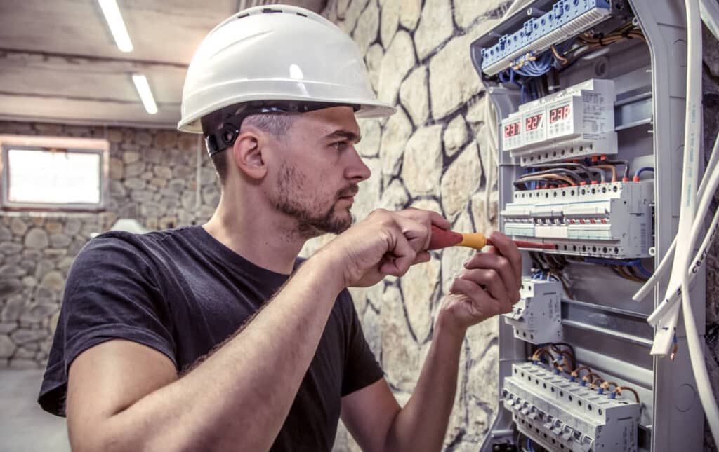 Un électricien professionnel contrôlant les circuits et les disjoncteurs d'une installation.