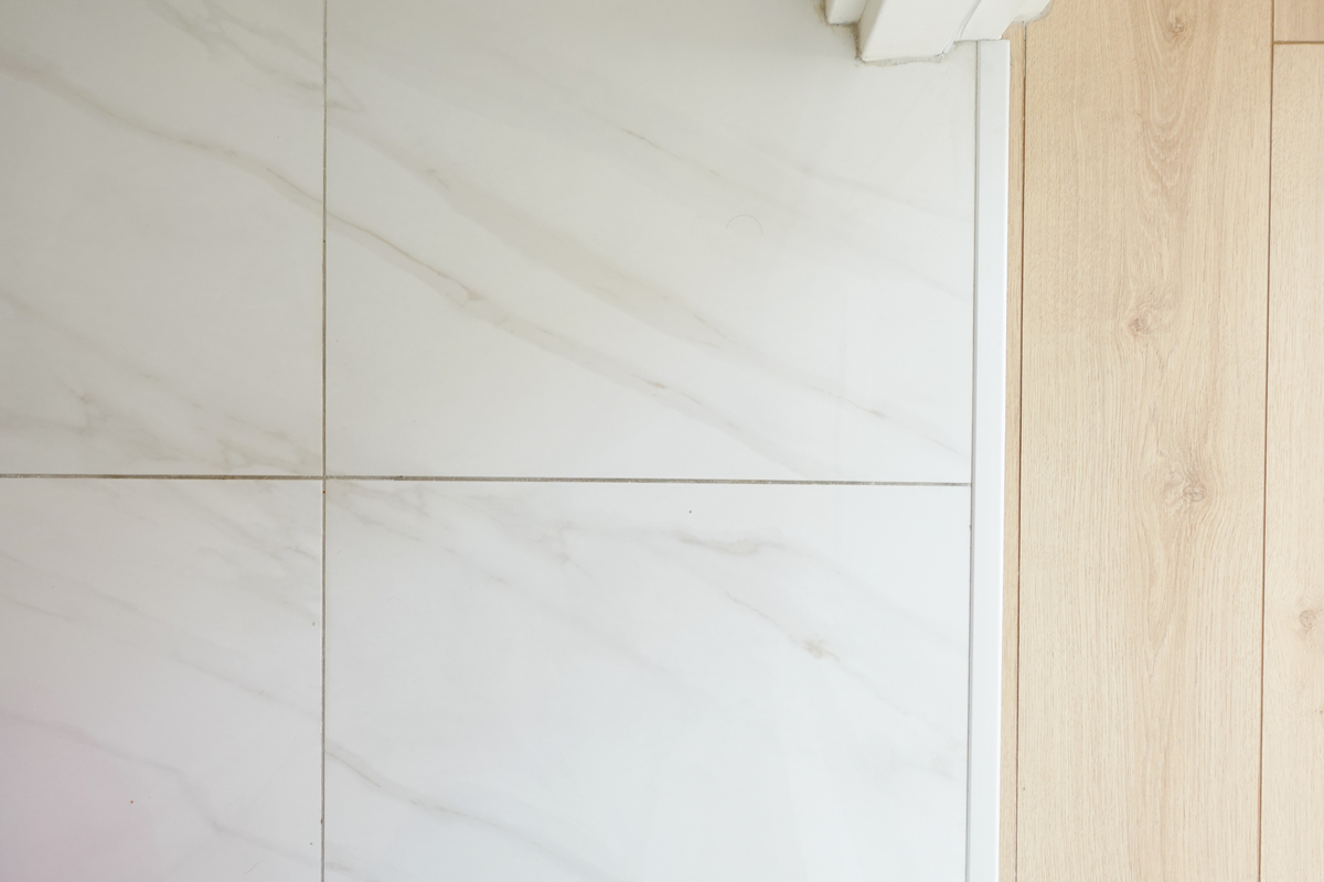 Gros plan sur des joints de carrelage de salle de bains dont la couleur ne correspond pas aux attentes initiales.