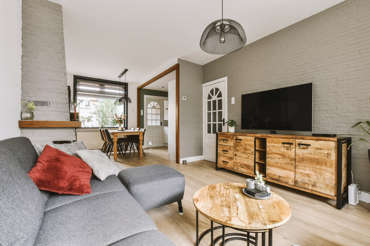 Un salon moderne chaleureux meublé avec un meuble TV et une table basse en bois massif durable.