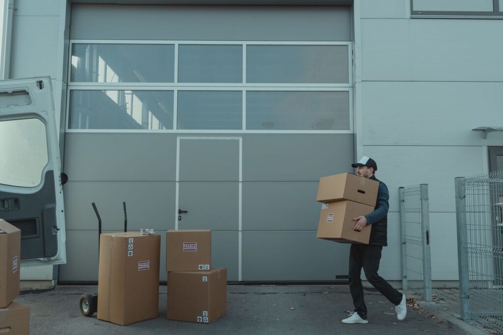 Un particulier rangeant ses affaires et ses cartons dans un box de stockage sécurisé en centre spécialisé.