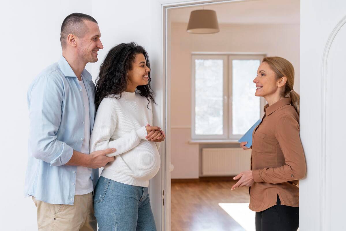 Famille visitant un appartement HLM avec un agent du bailleur social.